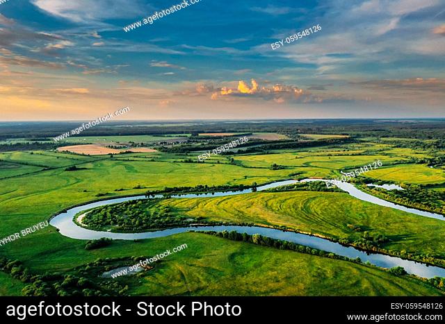 Aerial View Of Green Forest, Meadow And River Landscape In Sunny Evening. Top View Of European Nature From High Attitude In Summer Sunrise
