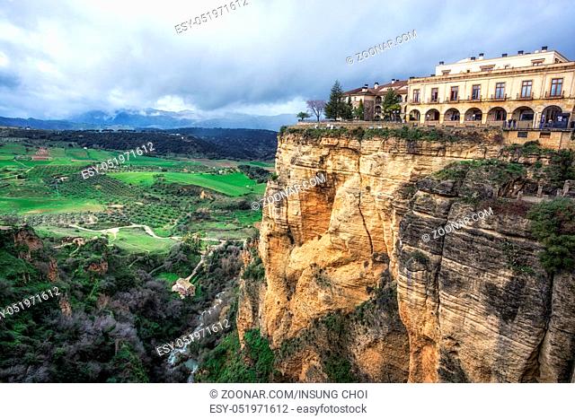 Ronda town and homes perched on el tajo canyon cliffsides with the view of the farms below