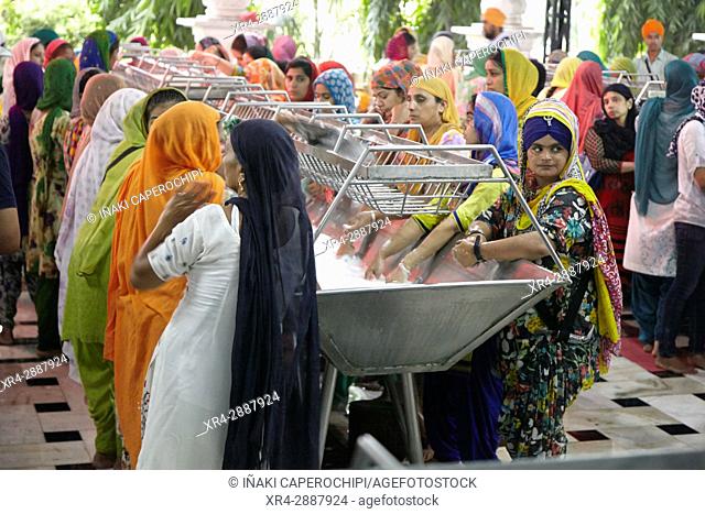 Women cleaning eating utensils. Dining Hall, Harmandir Sahib, Golden Temple, Amritsar, Punyab, India