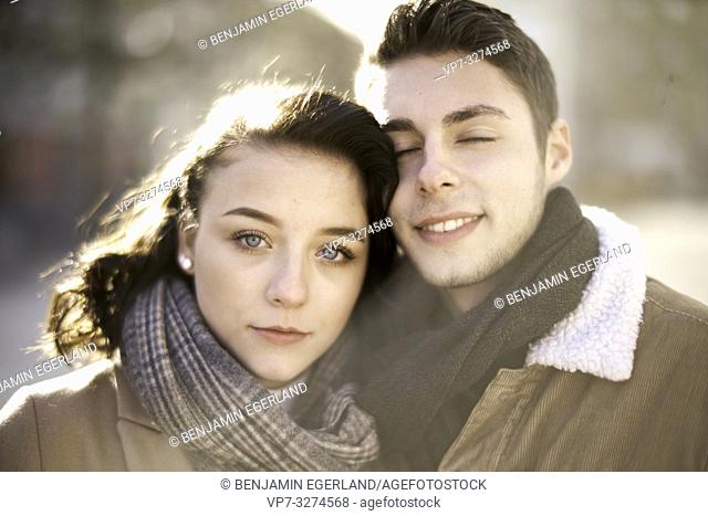 young teenage couple outdoors in sunlight, closed eyes, in city, in Cottbus, Brandenburg, Germany
