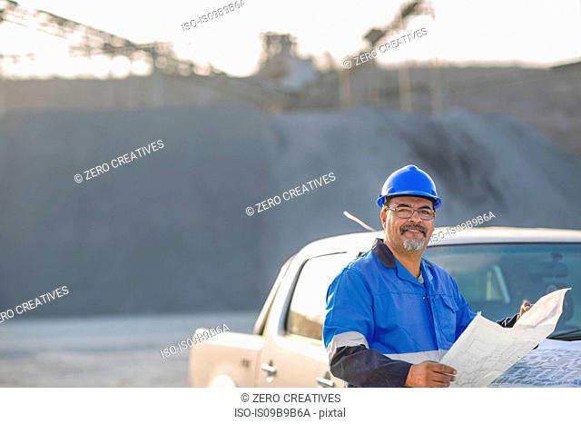 Portrait of quarry worker in quarry, holding document