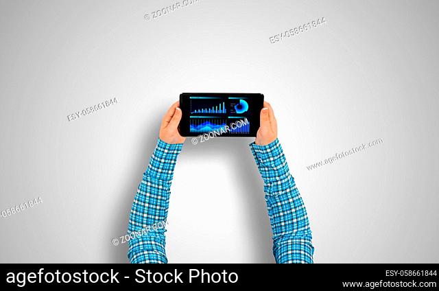 Top view of girl hands using tablet pc with diagrams and graphs on screen