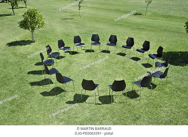 Office chairs in a circle in field