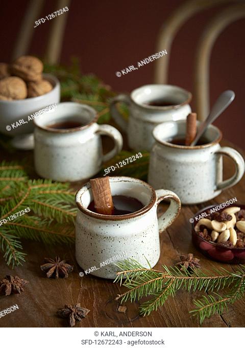 Rustic cups of mulled wine with cinnamon sticks