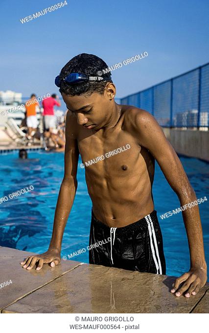 Teenage boy getting out of swimming pool