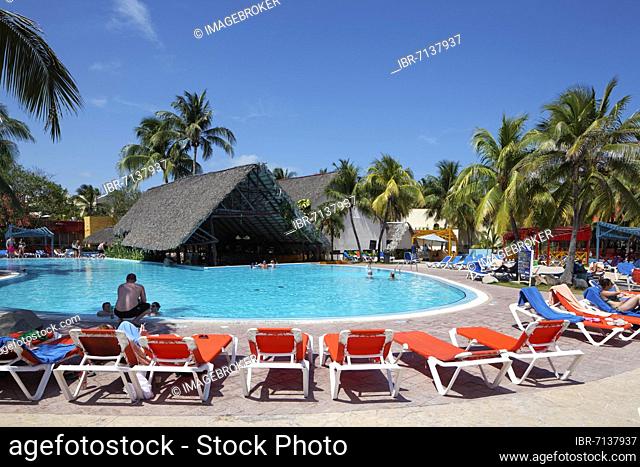 Pool, sun loungers, pool bar with palm leaf roof, coconut trees (Cocos nusifera) Hotel Brisas, Playa St. Lucia, Camagüey Province, Caribbean, Cuba
