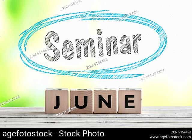 June seminar sign on a wooden stage on green background
