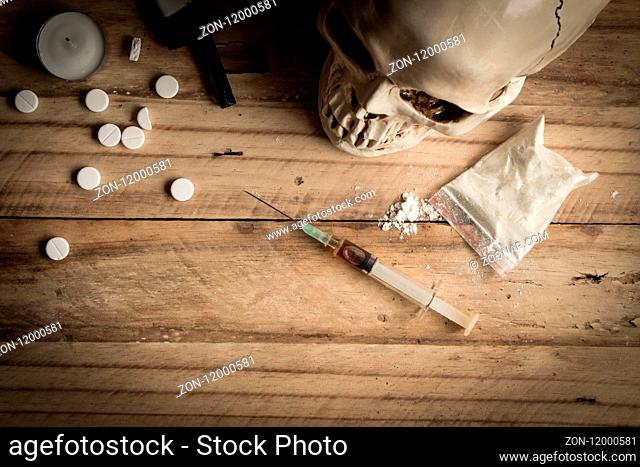 Drugs, powder, syringe and tablets on rustic wooden background. Drug addiction concept background with space for text