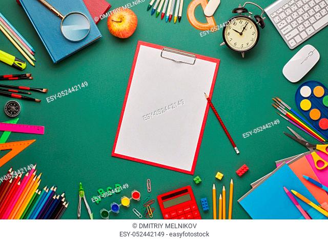 Red clipboard with blank sheet, computer keyboard, calculator and stationery accessories on green background. Top view, copy space