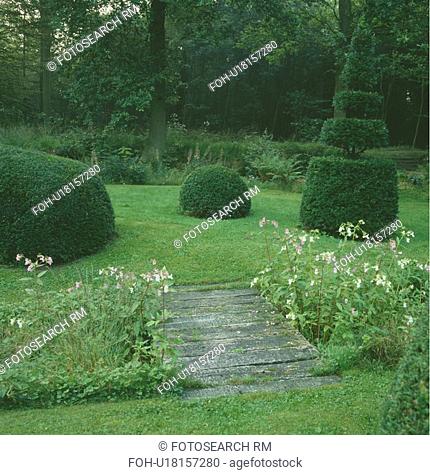 Counrty garden with plank bridge , topiary and woodland