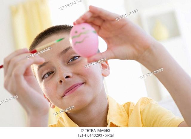 Young boy decorating an Easter egg