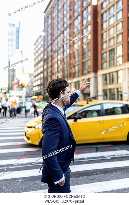 Businessman in the streets of Manhattan hailing a cab