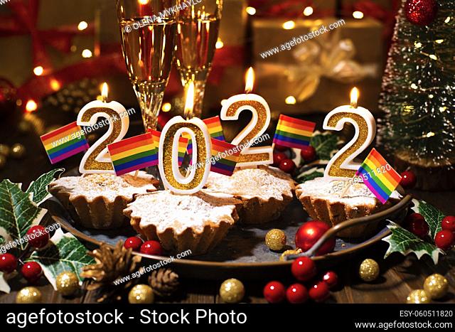 Food tray with cupcakes new year candles wineglasses and gay flags decorations