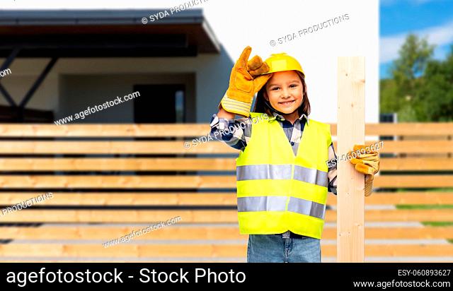 little girl in construction helmet with board