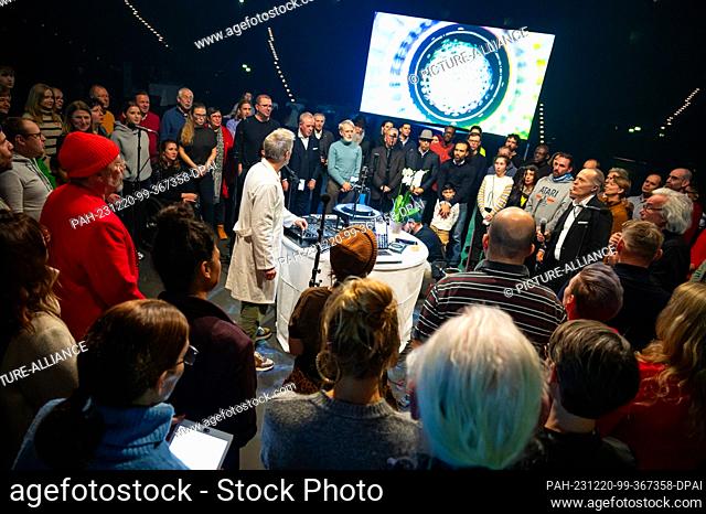 20 December 2023, Hamburg: The participants stand in a circle around the sound and image technology of sound artist Kymat and hum a sound