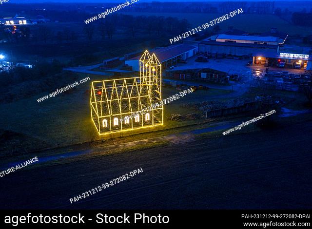 12 December 2023, Mecklenburg-Western Pomerania, Fahrbinde: The Christmas church, erected by scaffolders in the last few days and illuminated with fairy lights