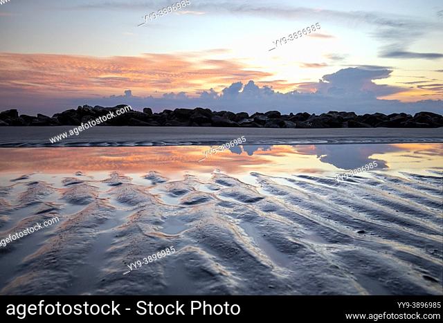 Sand patterns and reflections of a tidal pool at sunrise - Driftwood Beach - Jekyll Island, Georgia, USA