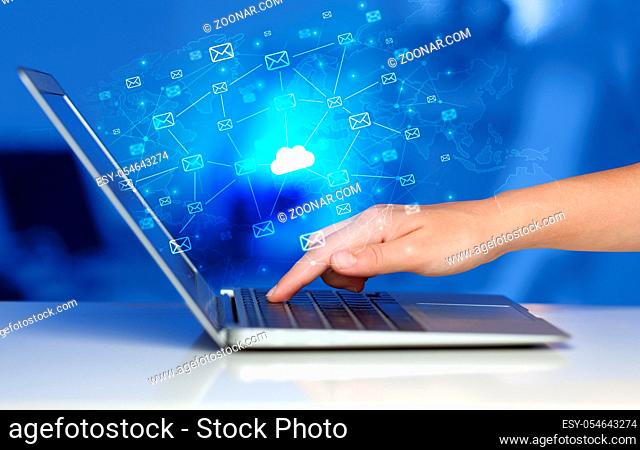 Hand using laptop with cloud computing and online storage concept