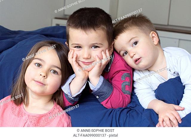 Young siblings relaxing together on bed, portrait