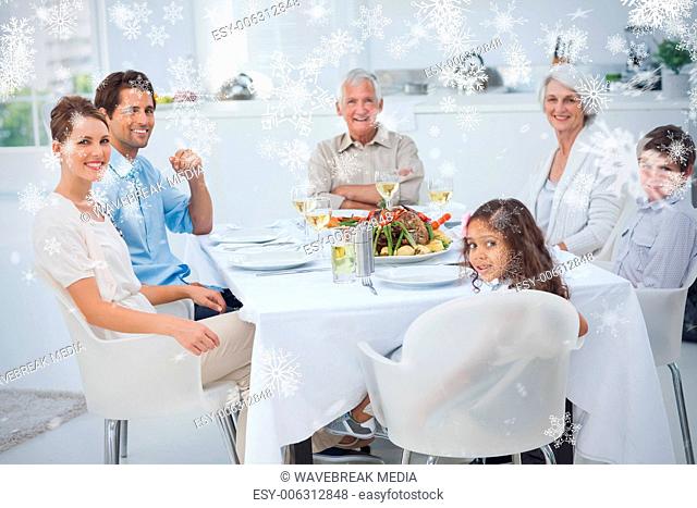 Composite image of family smiling at the dinner table