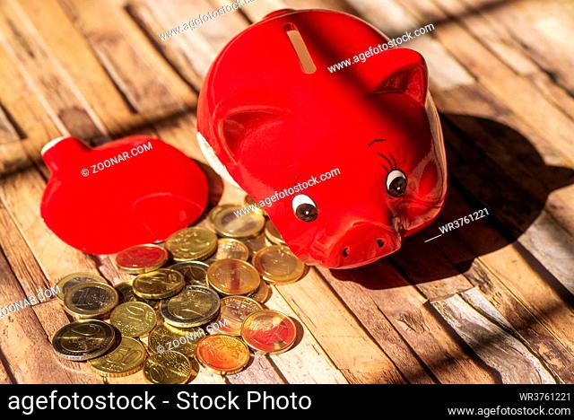 Ein zerbrochenes Sparschwein mit vielen Münzen