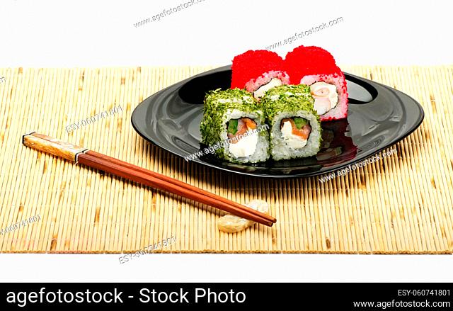 Sushi rolls on a plate with chopsticks isolated on a white background