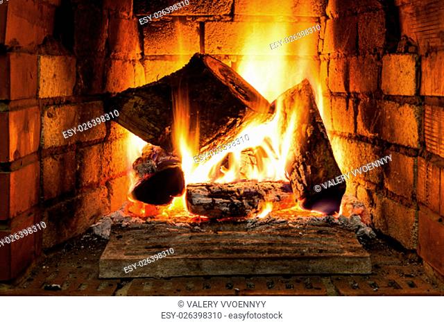 burning wood in fire-box of fireplace in country cottage