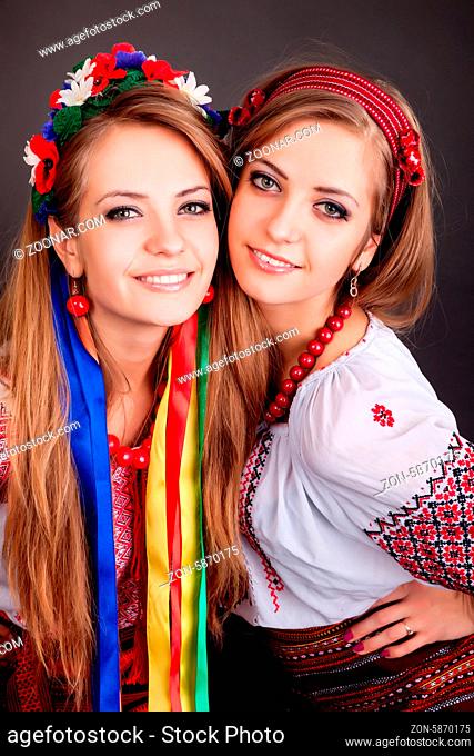 Young women in ukrainian clothes, with garland on black background