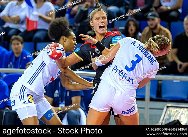 30 September 2022, France, Metz: Handball, women: International match, France - Germany. Germany's Xenia Smits (m) tries to hold her own against France's Oceane...