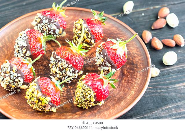 Fresh strawberries covered with dark chocolate and nuts