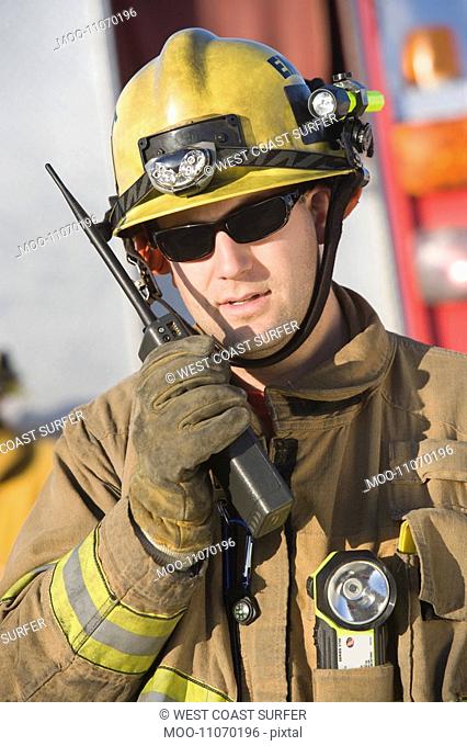 Firefighter holding two-way radio