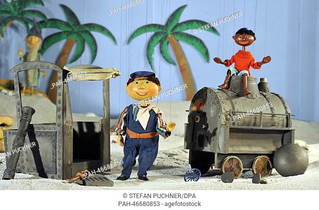 Marionettes Mr. Tur Tur (L-R), Lukas and Jim Knopf as well as broken locomotive Emma in a desert scenario at the Puppenkiste (puppet chest) museum in Augsburg