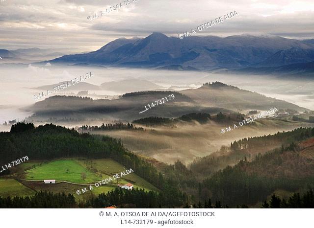 Fog over Goierri valley with Txindoki mountain of the Aralar mountain range in background. Guipuzcoa, Basque Country, Spain