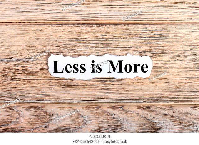 less is more text on paper. Word less is more on torn paper. Concept Image