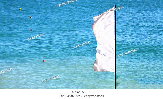 a waving white flag with a blue sea and signaling buoys in the background
