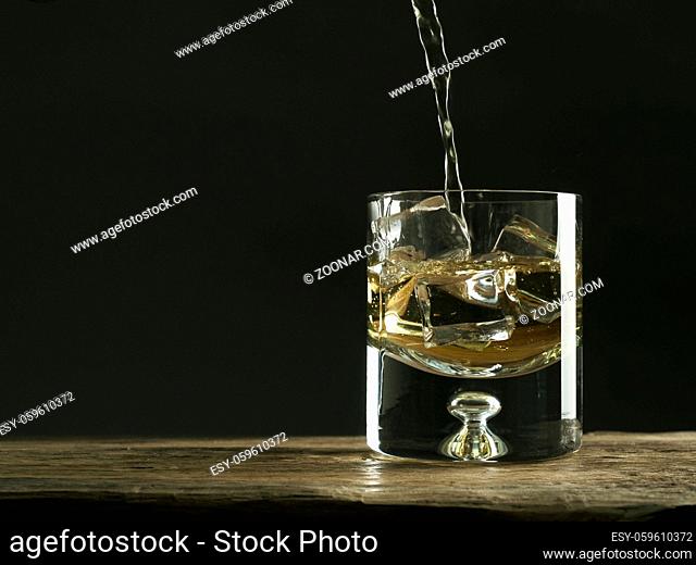 Glass of whiskey on a rustic wooden table, luxury drink, space for text or image