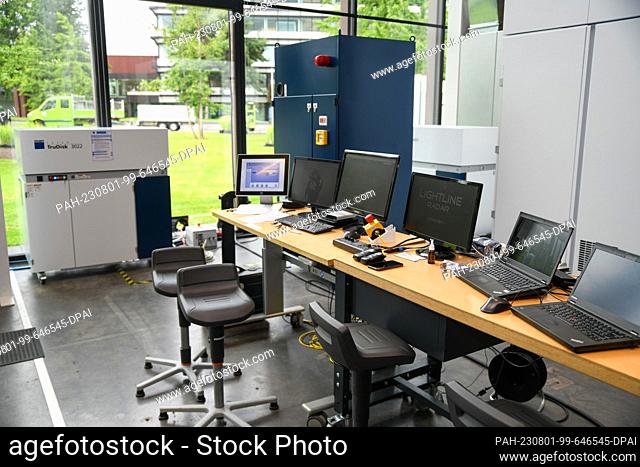 01 August 2023, Baden-Württemberg, Ditzingen: Several surveillance screens stand near a laser machine. A laser from the Trumpf company is to shine in the sky as...