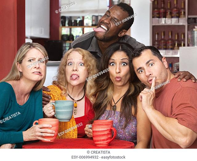 Mixed group of friends making faces in a cafe