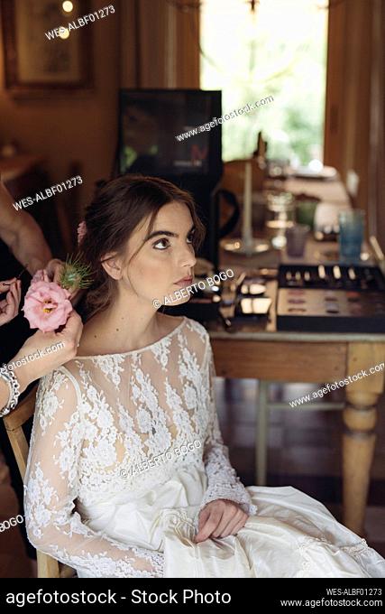 Hairdresser with flower for hair of bride