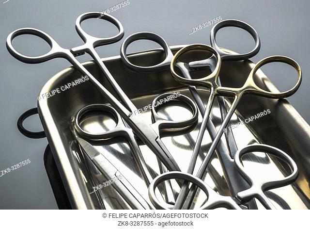Some scissors for surgery on a tray in an operating theater, conceptual image, horizontal composition