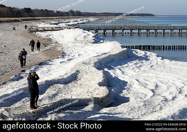 22 February 2021, Mecklenburg-Western Pomerania, Zingst: Metre-high piles of ice and snow still lie on the Baltic Sea beach even at temperatures around ten...