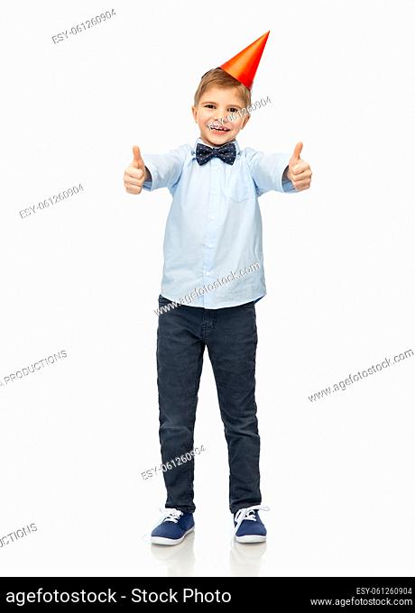 boy in birthday party hat showing thumbs up