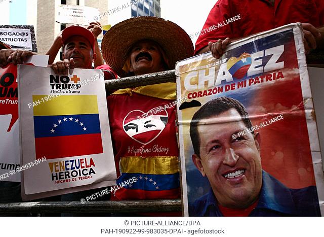 21 September 2019, Venezuela, Caracas: Demonstrators are holding posters, including the portrait of former Venezuelan President Chavez