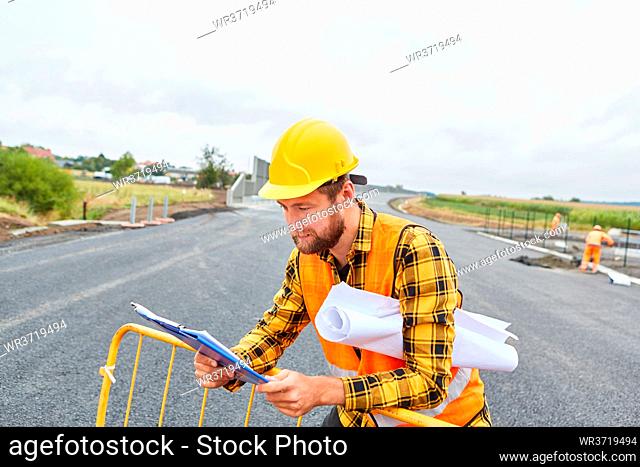 Arbeiter auf der Baustelle vom Straßenbau mit Checkliste und Lageplan für Bebauung