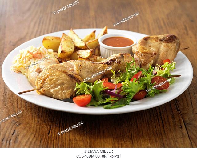 Plate of chicken with salad and potatoes