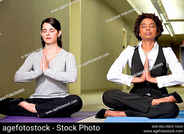 Women meditating in corridor