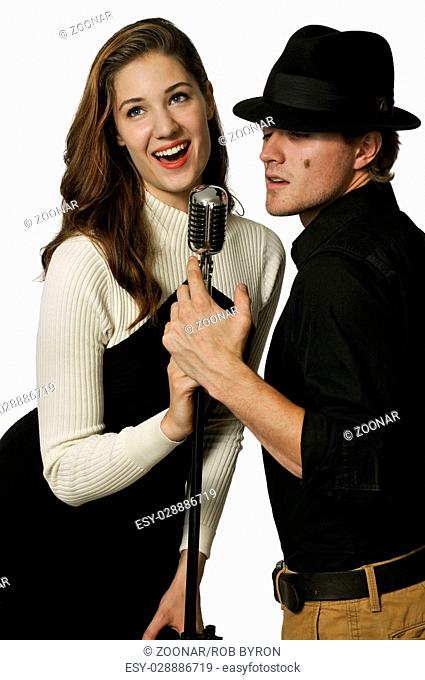 Man and woman singing into microphone