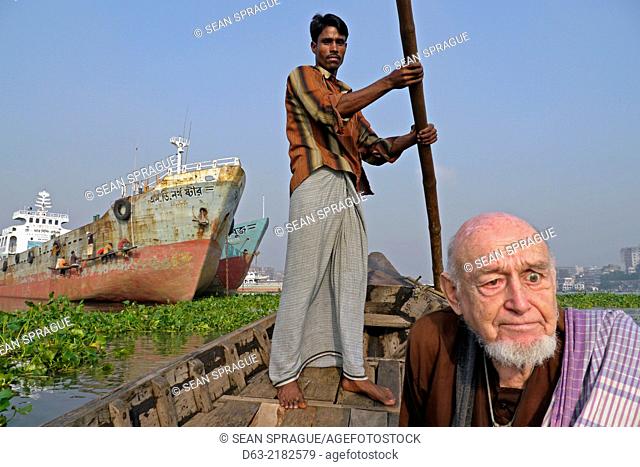 BANGLADESH. American Catholic missionary priest in a boat on the Buriganga River, Dahka