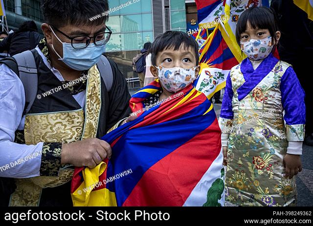 Man covers child with Tibetan flag as Tibetans and Taiwanese who support Tibetan freedom protest on the streets of Taipei