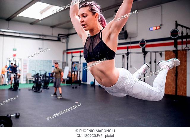 Young woman swinging in mid air in gym
